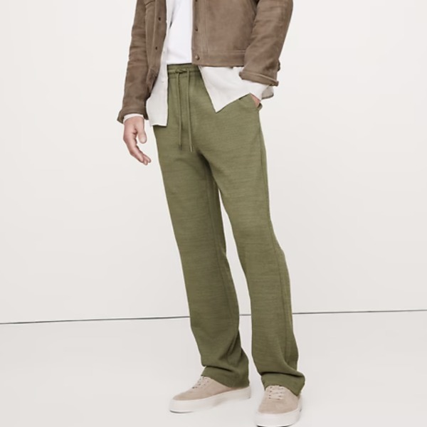 Man wearing beach slacks with an unbuttoned shirt and casual sneakers