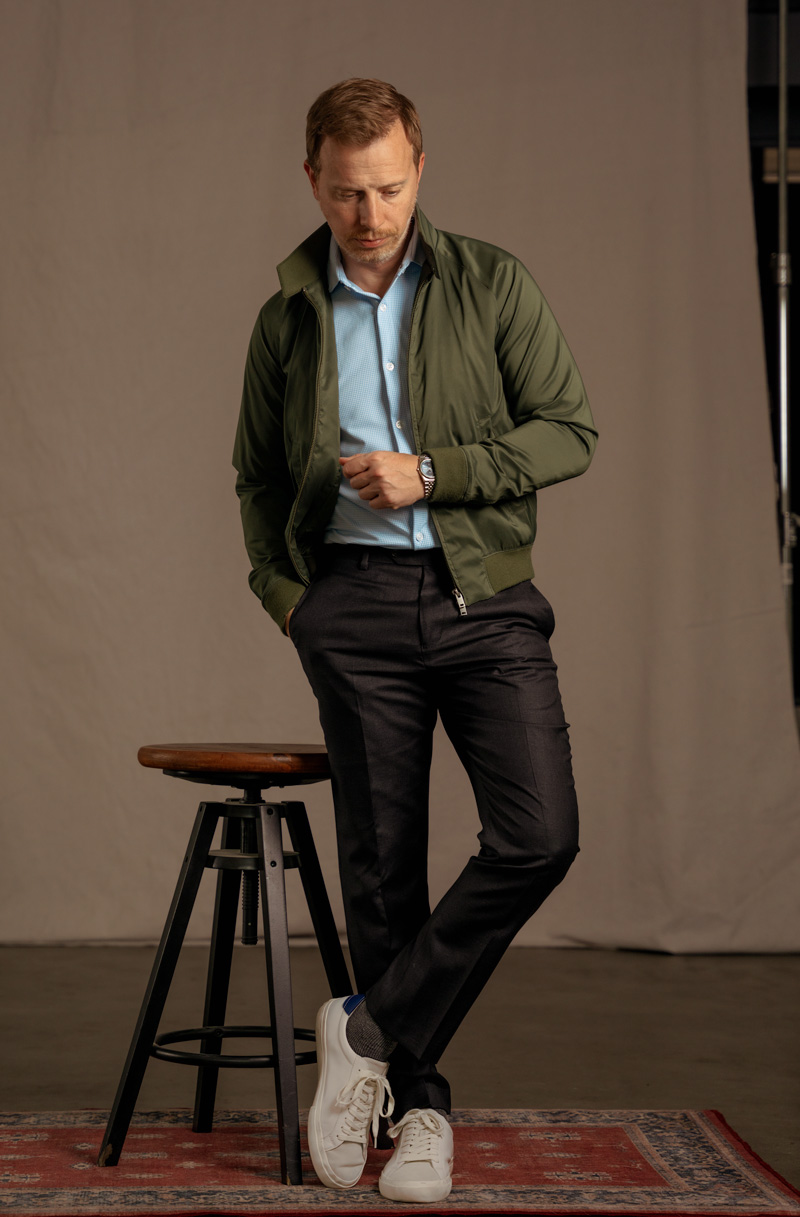 man wearing a green Harrington jacket and blue dress shirt