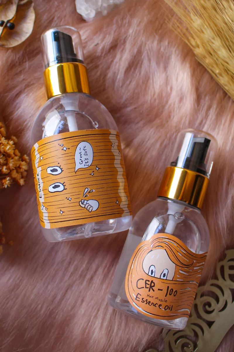 Bottle of CER-100 Collagen Coating Hair A+ Muscle Essence near Bottle of CER-100 Essence Oil