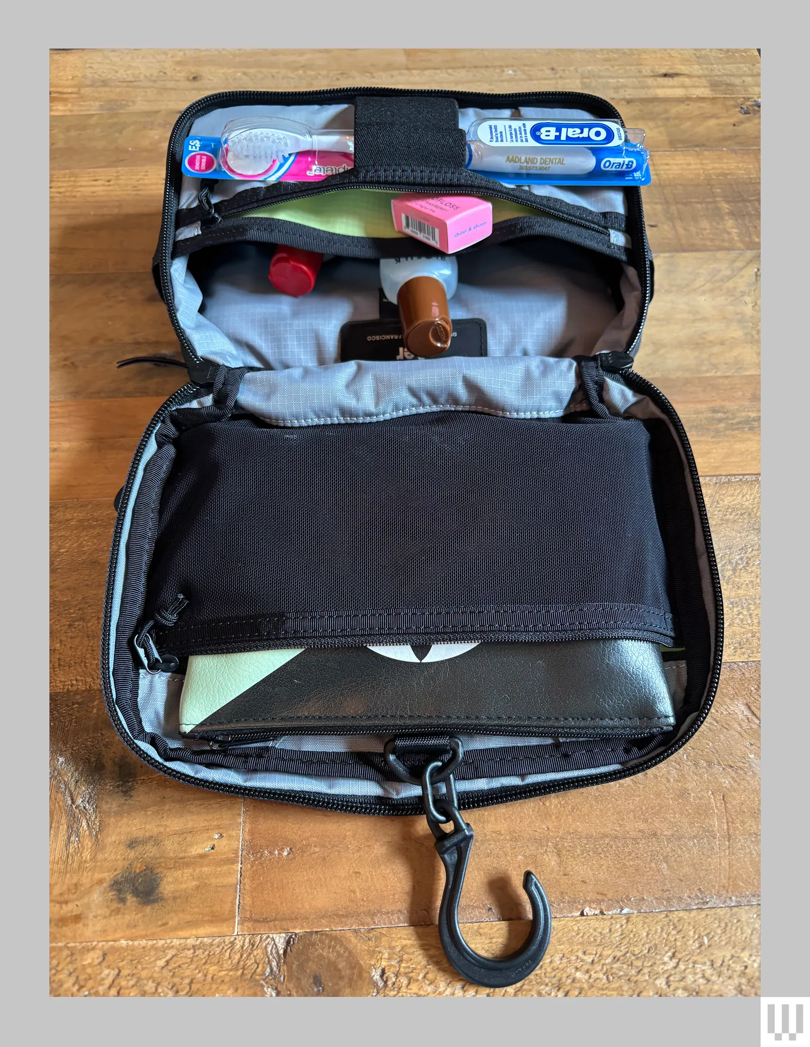 The Aer Travel Kit 2 a black toiletry bag laying open and flat with toiletries in the pouches and pockets